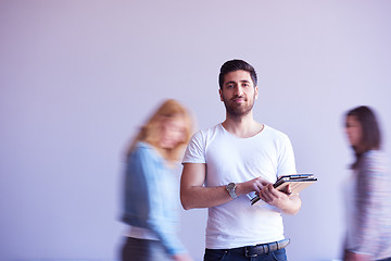 Image showing student working on tablet, people group passing by