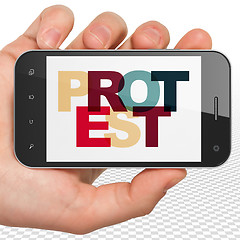 Image showing Politics concept: Hand Holding Smartphone with Protest on  display