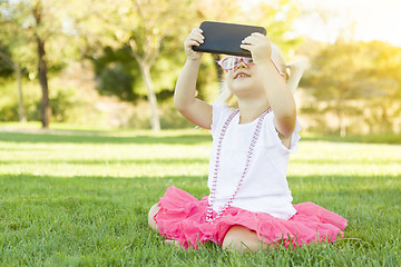 Image showing Little Girl In Grass Taking Selfie With Cell Phone