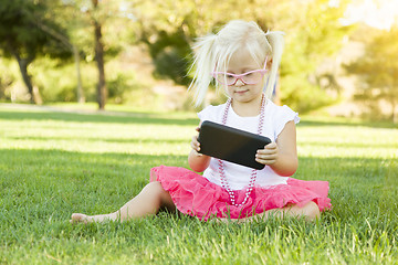 Image showing Little Girl In Grass Playing With Cell Phone