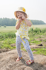 Image showing Attractive little girl relaxes on hay straw