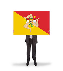 Image showing Smiling businessman holding a big card, flag of Sicily