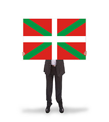 Image showing Smiling businessman holding a big card, flag of Basque Country