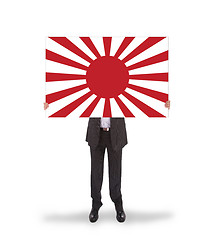 Image showing Smiling businessman holding a big card, flag of Japan