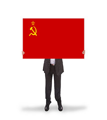 Image showing Smiling businessman holding a big card, flag of the USSR