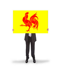 Image showing Smiling businessman holding a big card, flag of Wallonia