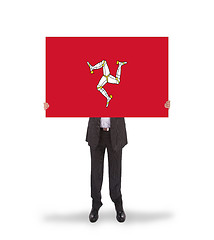 Image showing Smiling businessman holding a big card, flag of Isle of Man