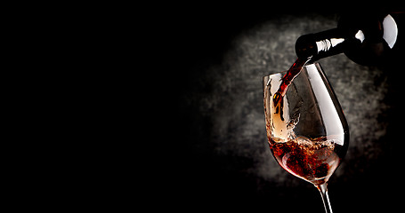 Image showing Pouring wine on black