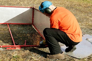 Image showing Man grinding steel