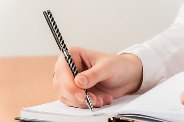 Image showing Business woman writing in notebook