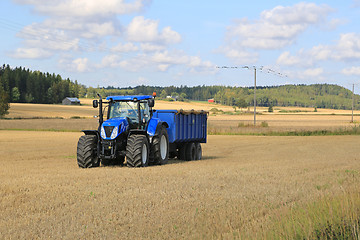 Image showing New Holland Tractor and Blue Trailer Autumn Field Landscape