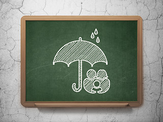 Image showing Safety concept: Family And Umbrella on chalkboard background