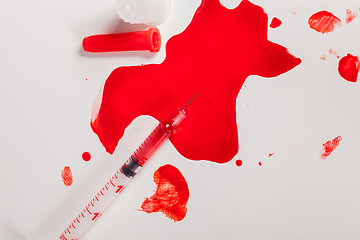 Image showing Syringe Squirting Red Blood onto White Background