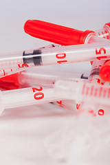 Image showing Pile of Empty Syringes with Red Safety Caps