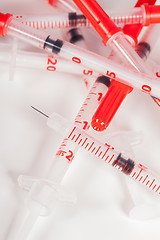 Image showing Pile of Empty Syringes with Red Safety Caps