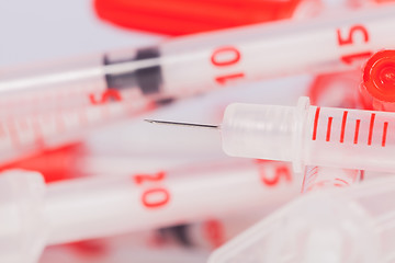 Image showing Pile of Empty Syringes with Red Safety Caps