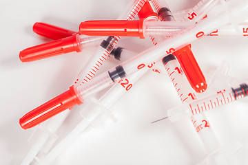 Image showing Pile of Empty Syringes with Red Safety Caps