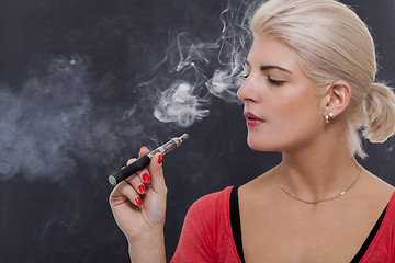 Image showing Stylish blond woman smoking an e-cigarette