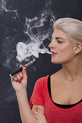 Image showing Stylish blond woman smoking an e-cigarette