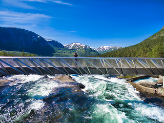 Image showing Girl on bridge above waterfall