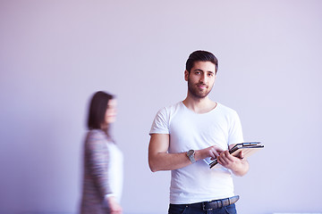 Image showing student working on tablet, people group passing by