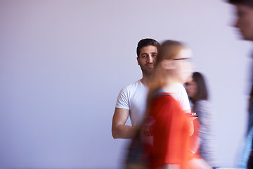 Image showing student working on tablet, people group passing by