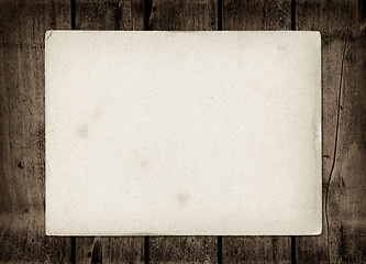 Image showing Old textured paper sheet on a dark wood table