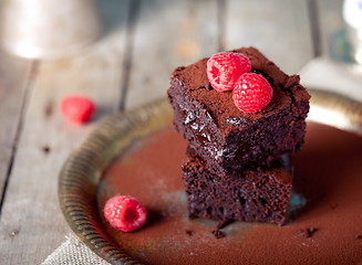 Image showing Brownies with raspberry on a wooden background.