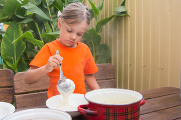 Image showing Sleepy girl on breakfast places semolina