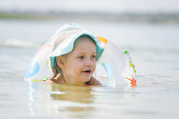 Image showing Four-year girl with a circle floating in the river