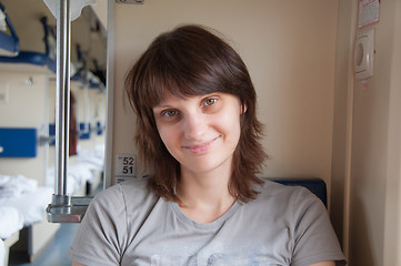 Image showing Young girl sitting on the side in place of second-class train carriage