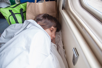 Image showing Young girl asleep in a second-class train carriage