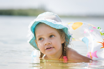 Image showing Thoughtful four-year girl bathes in the river