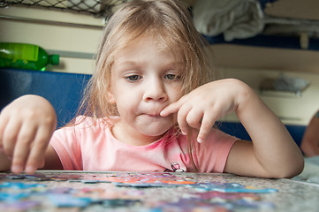 Image showing Girl collects puzzles while on a train