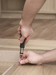 Image showing Hands with a screwdriver