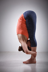 Image showing Woman practices yoga asana Uttanasana