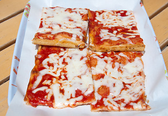 Image showing Slices of pizza topped with tomato, mozzarella and olive oil