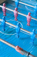 Image showing football players and through slats of wood, a play for children