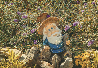 Image showing Interesting statue of a dwarf among the flowers.