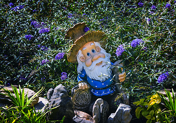 Image showing Interesting statue of a dwarf among the flowers.