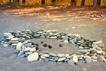 Image showing Sea stones on the beach and pine cones.