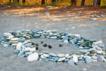 Image showing Sea stones on the beach and pine cones.