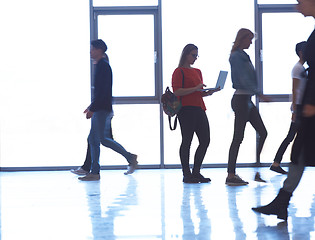 Image showing student girl standing with laptop, people group passing by