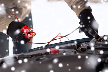 Image showing closeup of man under bonnet with starter cables