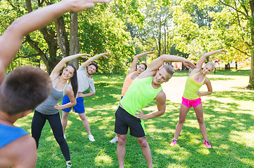 Image showing group of friends or sportsmen exercising outdoors