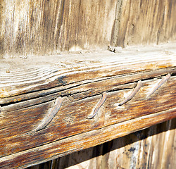 Image showing metal nail dirty stripped paint in the brown   red wood door and