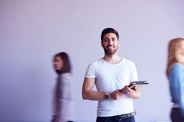 Image showing student working on tablet, people group passing by