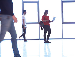 Image showing student girl standing with laptop, people group passing by