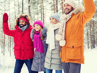 Image showing group of friends waving hands in winter forest