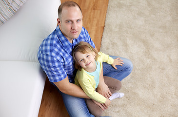 Image showing happy father and daughter sitting on sofa at home